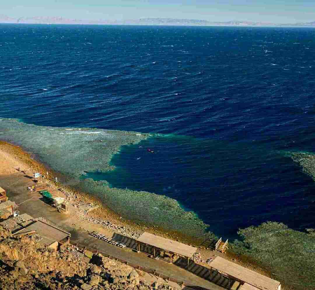 Blue Hole Dahab seen from the shore, the dark circle cut into the reef