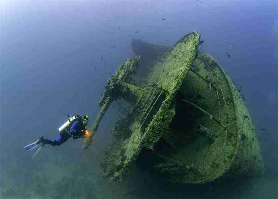 Diver at the stern of a deep wreck